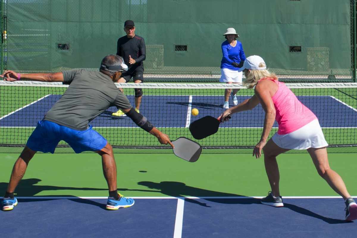 Pickleball mixed doubles action colorful court.