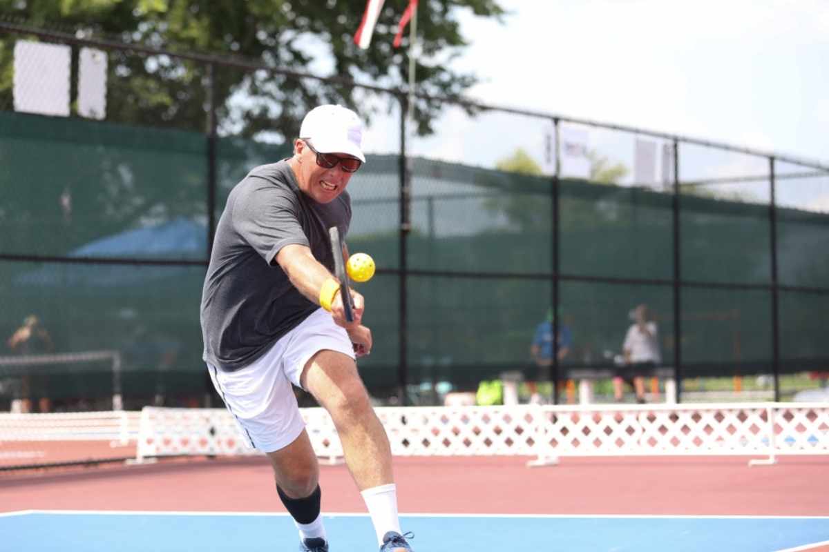 A tournament pickleball players hits a shot.